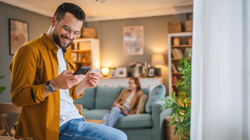 Two people buying goods online using a smart phone.